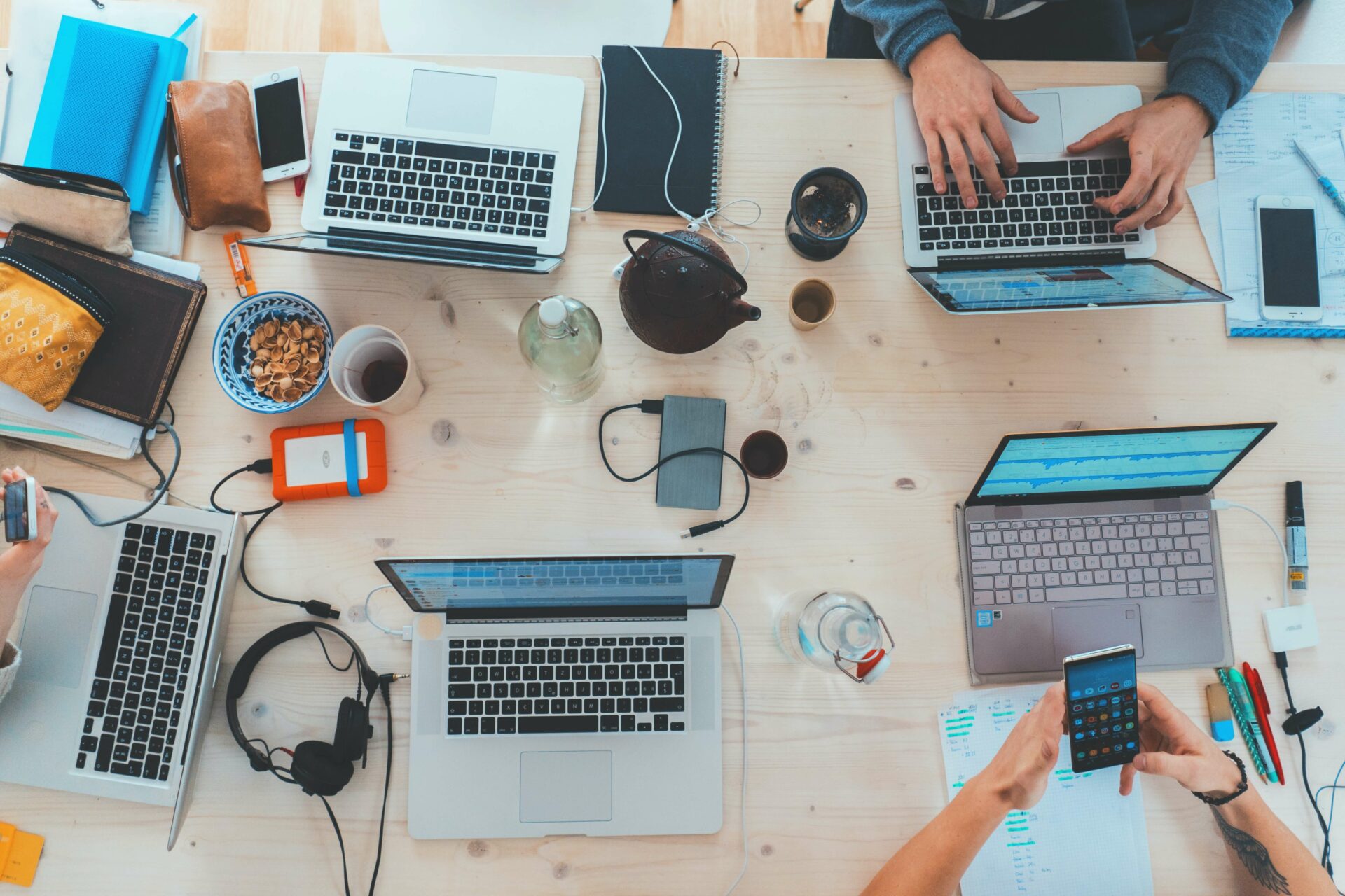 laptops on table with people working