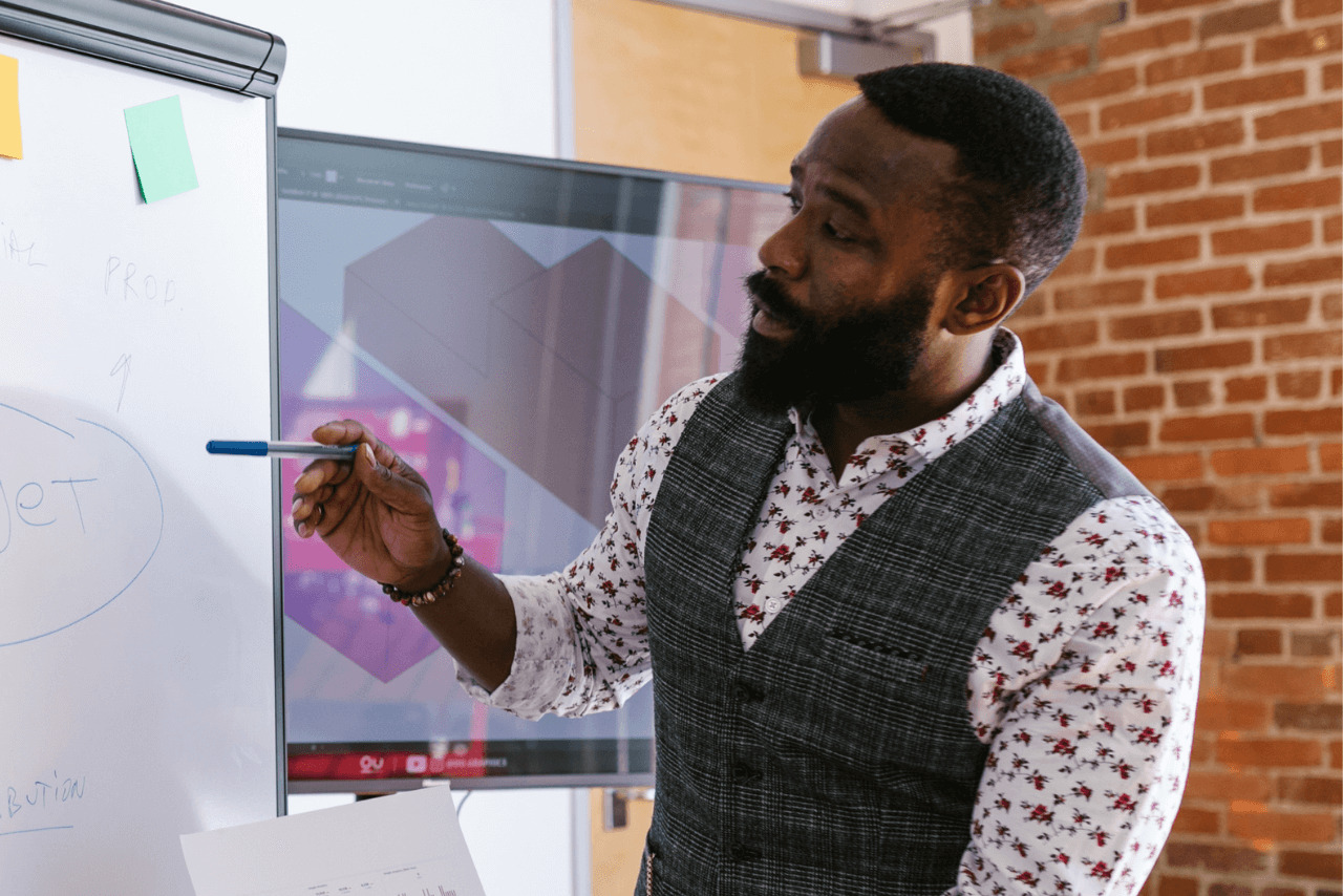 teacher showing his class examples on whiteboard