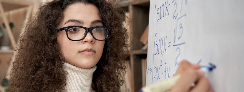 teacher writing maths on a whiteboard