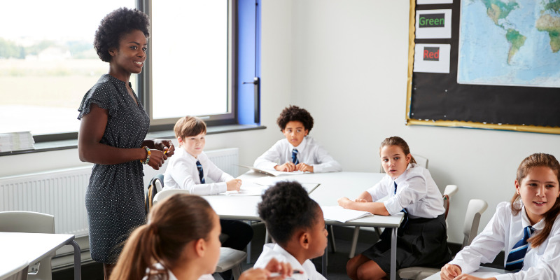 teacher walking around classroom talking with students