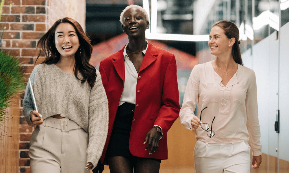 image of three women walking down corridor smiling